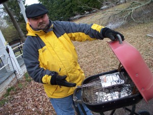 Geof grilling fish over a charcoal grill.